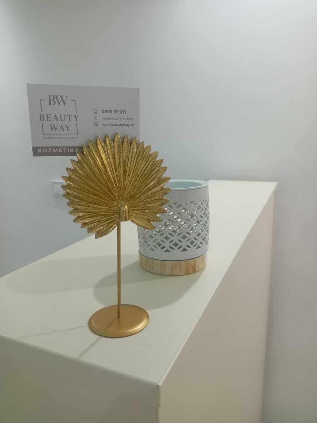Vizitka Beauty way pri zlatej dekorácii na recepcii